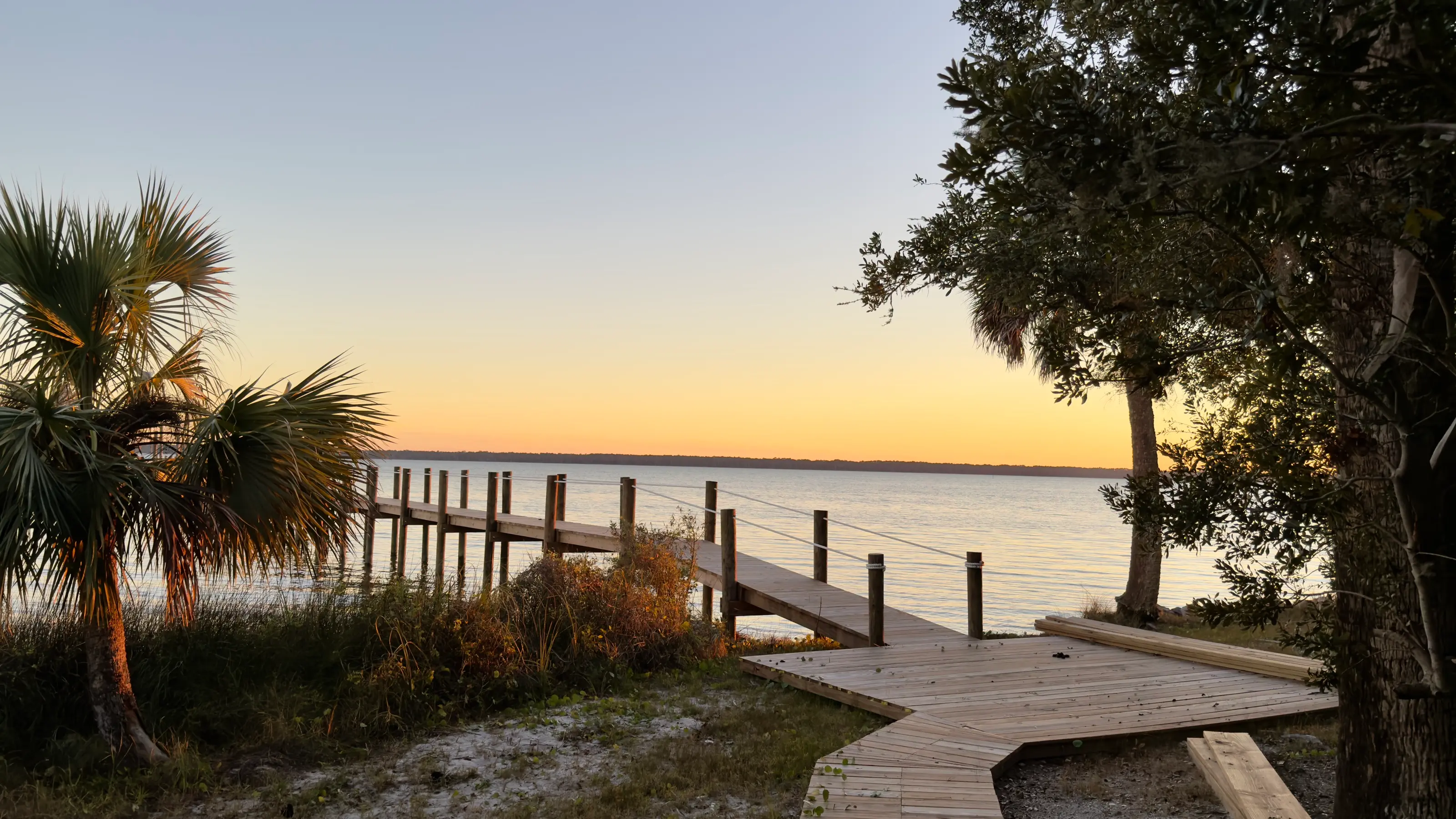The dock at 11 Mile reaching into St. Vincent Sound at sunset, palms in silhouette.