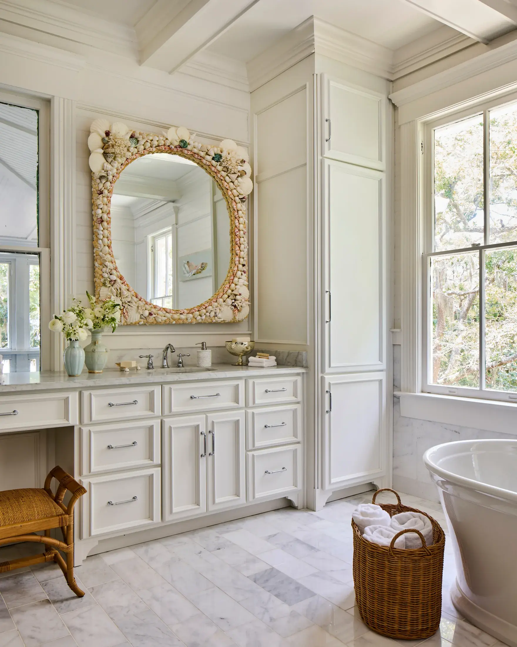 A marble vanity beneath a mirror framed entirely in shells.