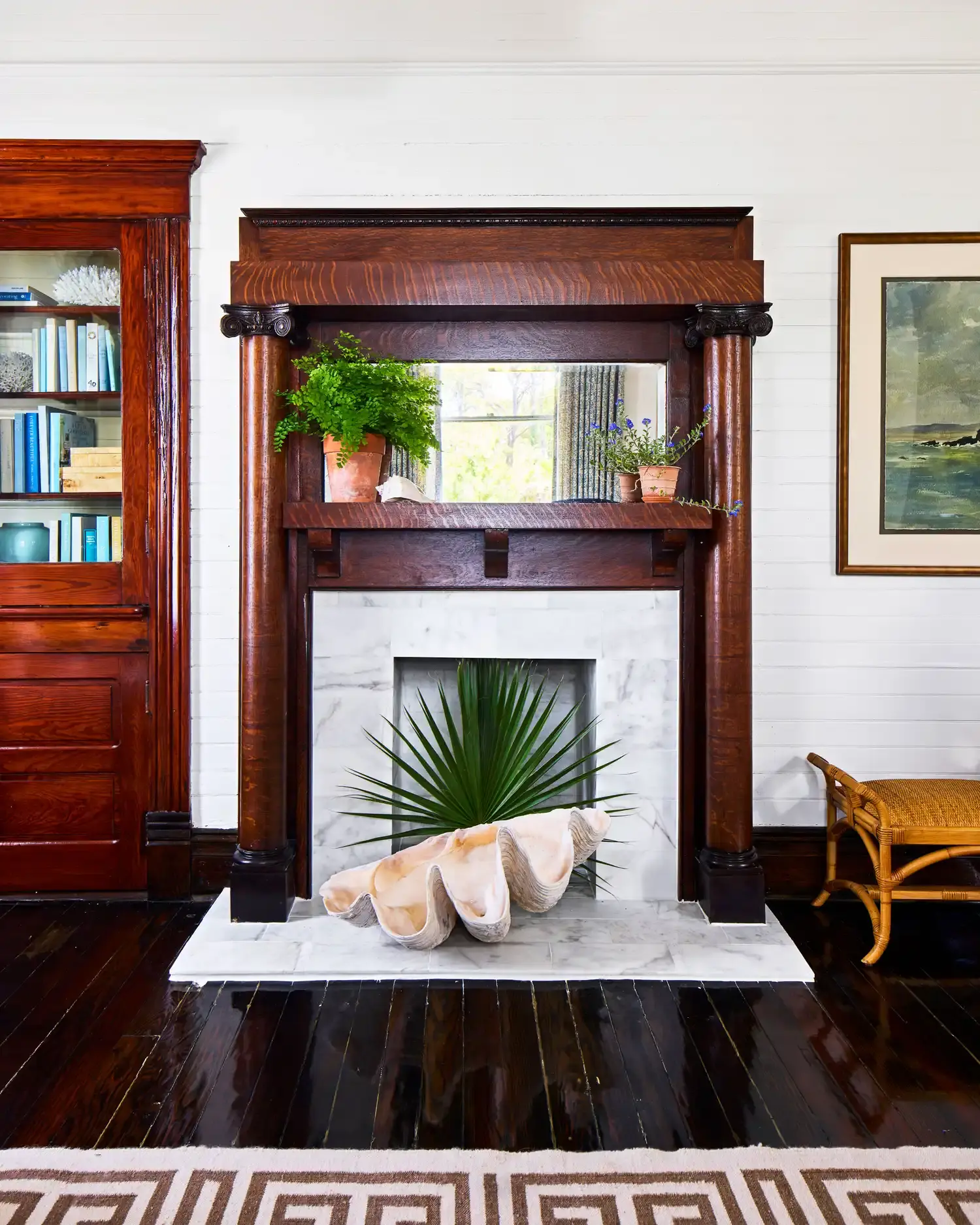 A carved mantel above a marble firebox.
