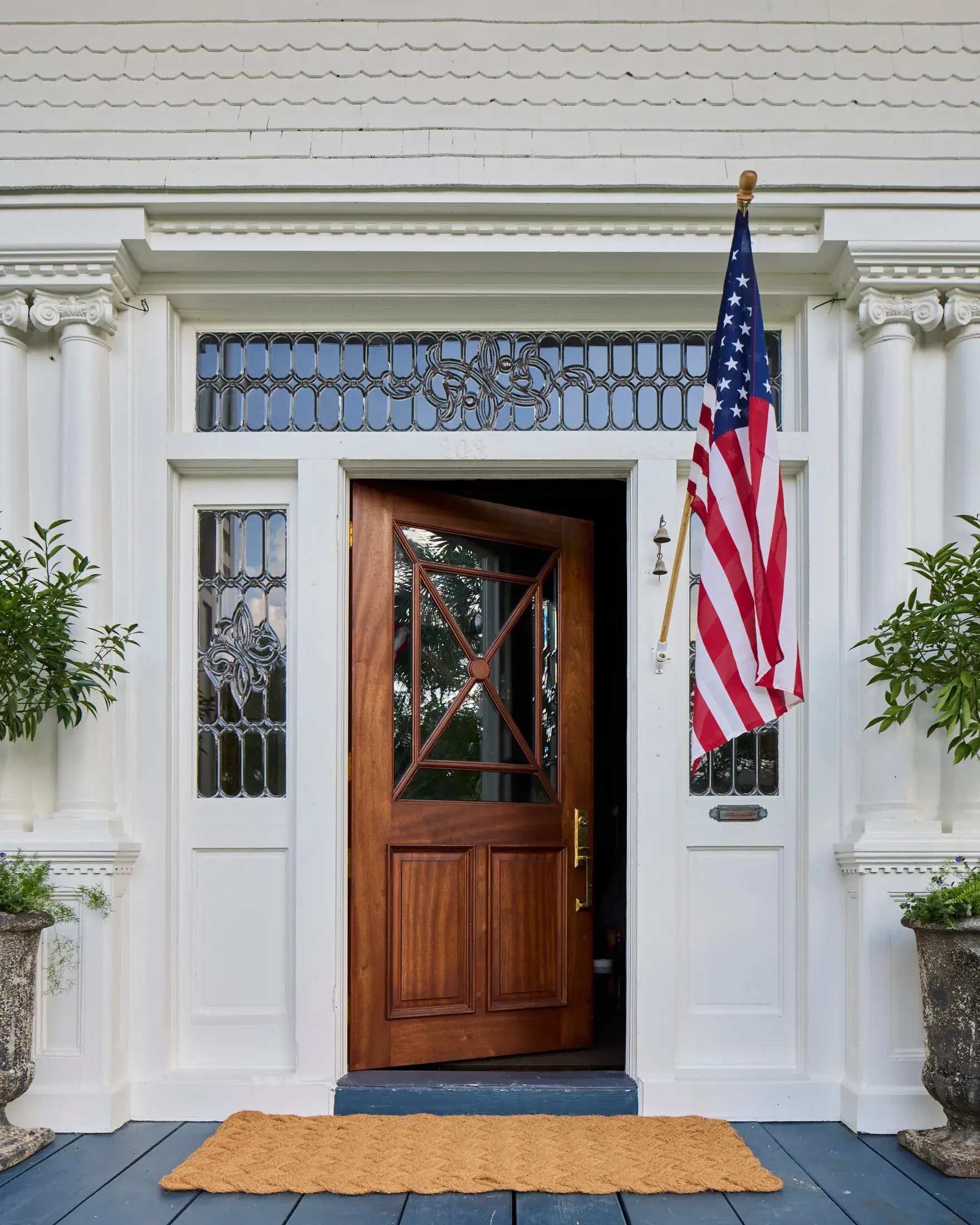 The mahogany front door under its leaded glass transom.